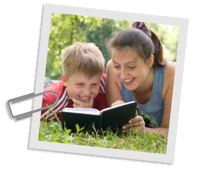 Auf dem Bild ist eine Studentin zusammen mit einem Nachhilfeschler zu sehen, die ein Buch lesen. Beide liegen auf einer Wiese.
